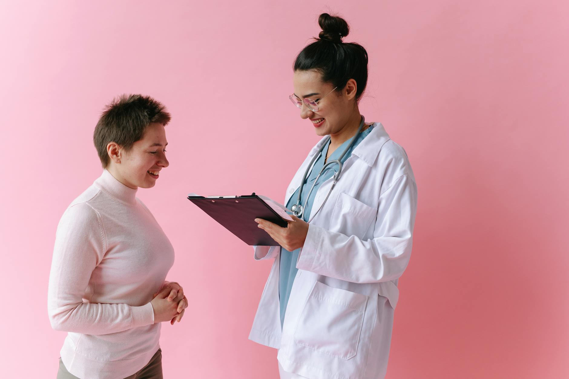 A doctor in a white coat consulting with a smiling patient, representing the ongoing partnership between patient and provider when optimizing ADHD medication